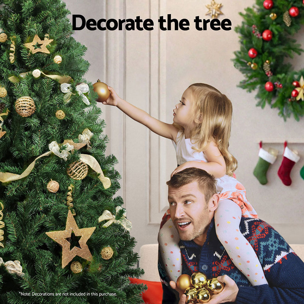 Prelit Christmas tree decorated with gold ornaments and hanging star decorations