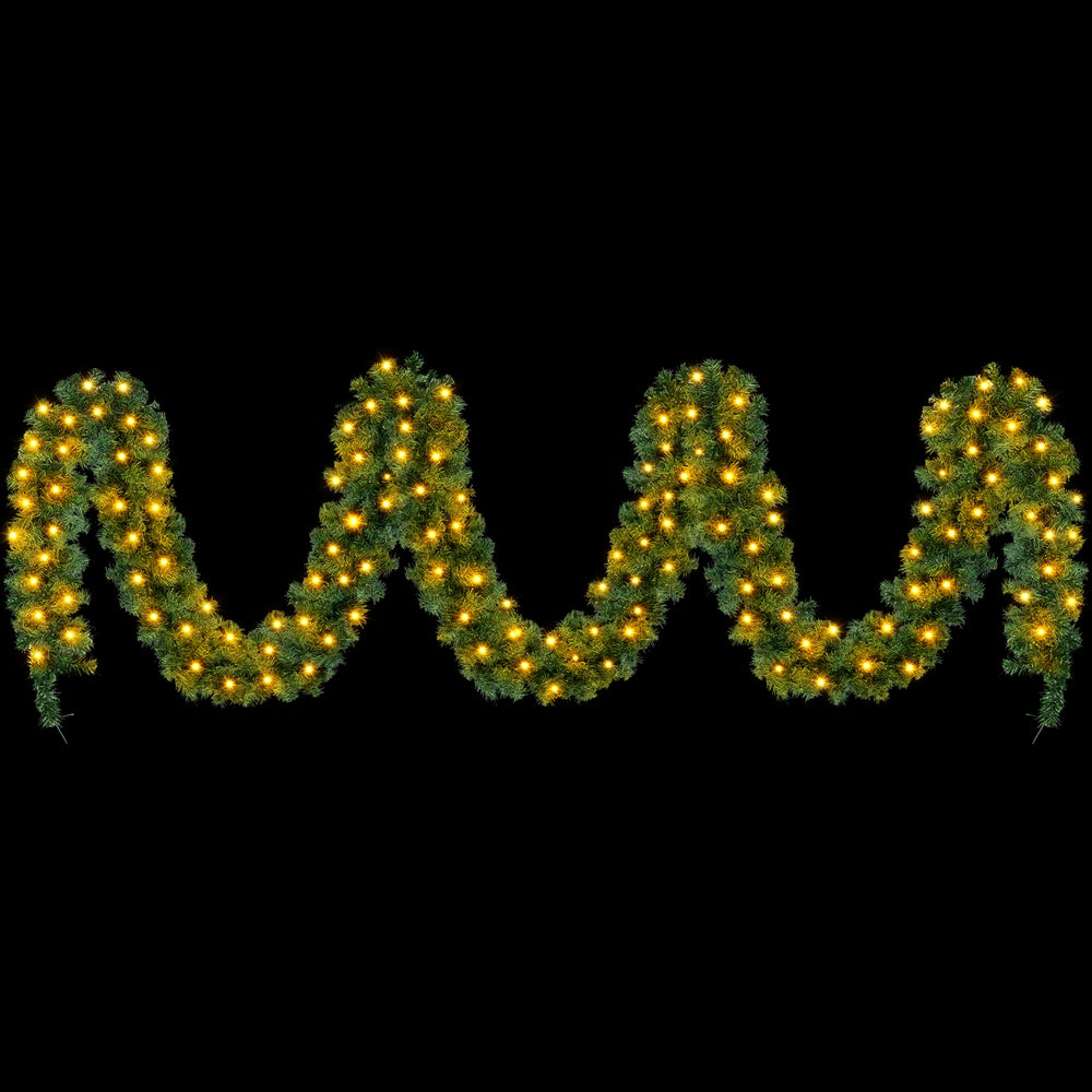 Christmas garland LED lights with green foliage and warm yellow bulbs, scalloped shape