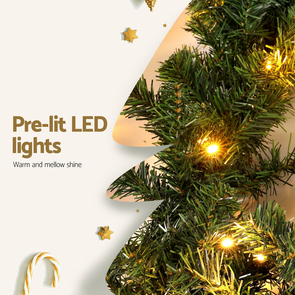 Pre-lit green Christmas garland branch with warm LED bulbs and star accents