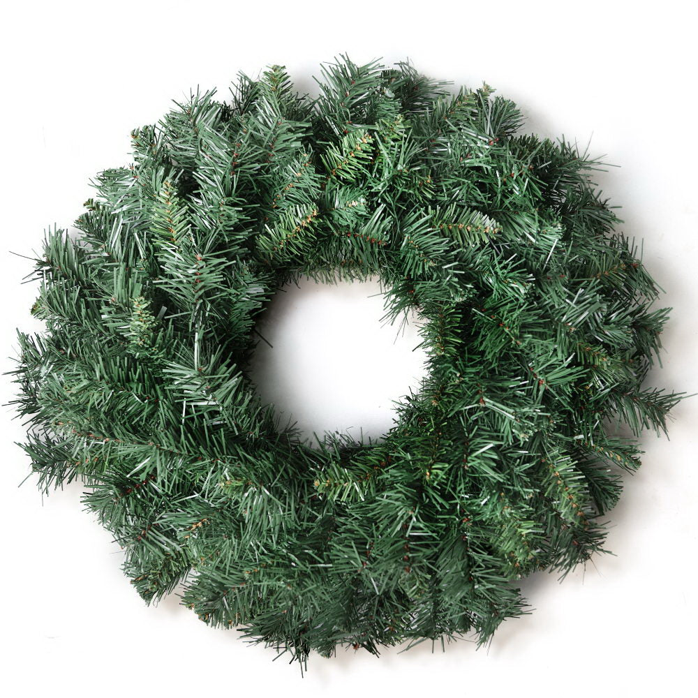 Green artificial Christmas wreath with dense pine tips, round door decoration