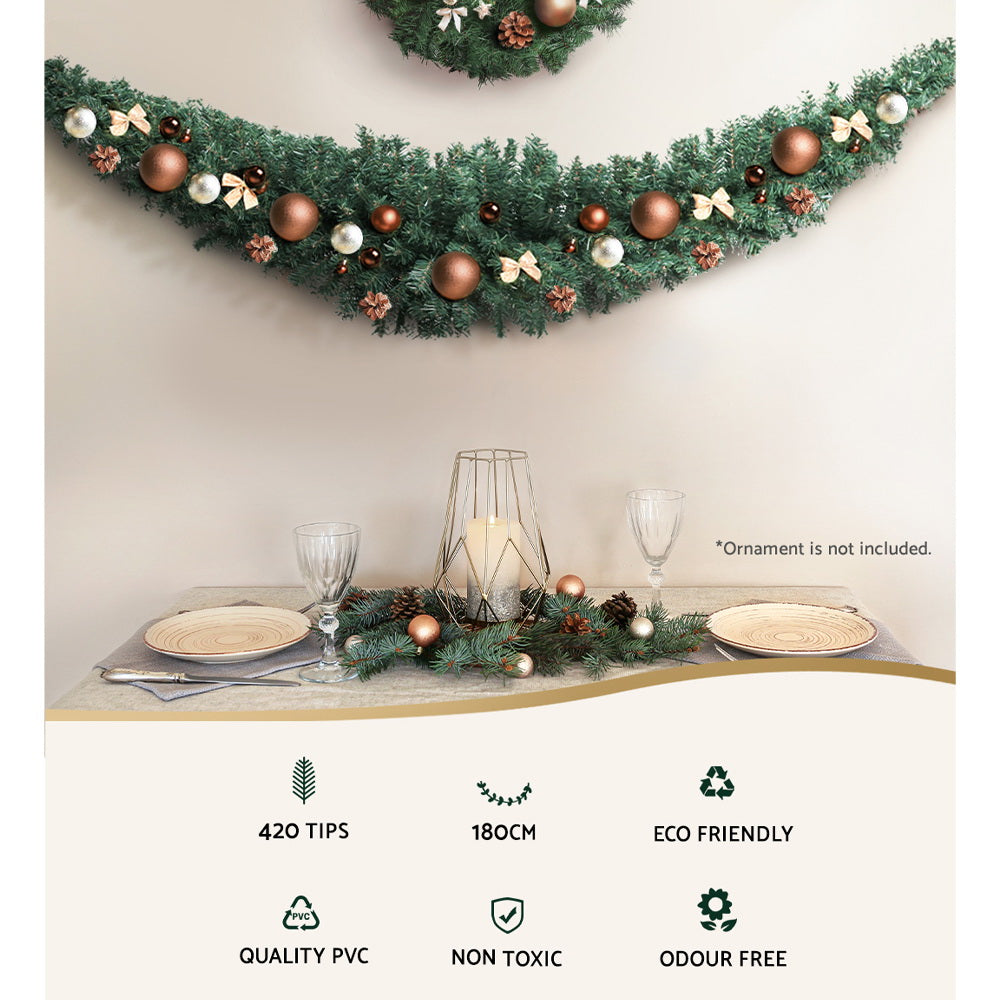 Decorated green Christmas garland with brown baubles, white bows, and pine tips