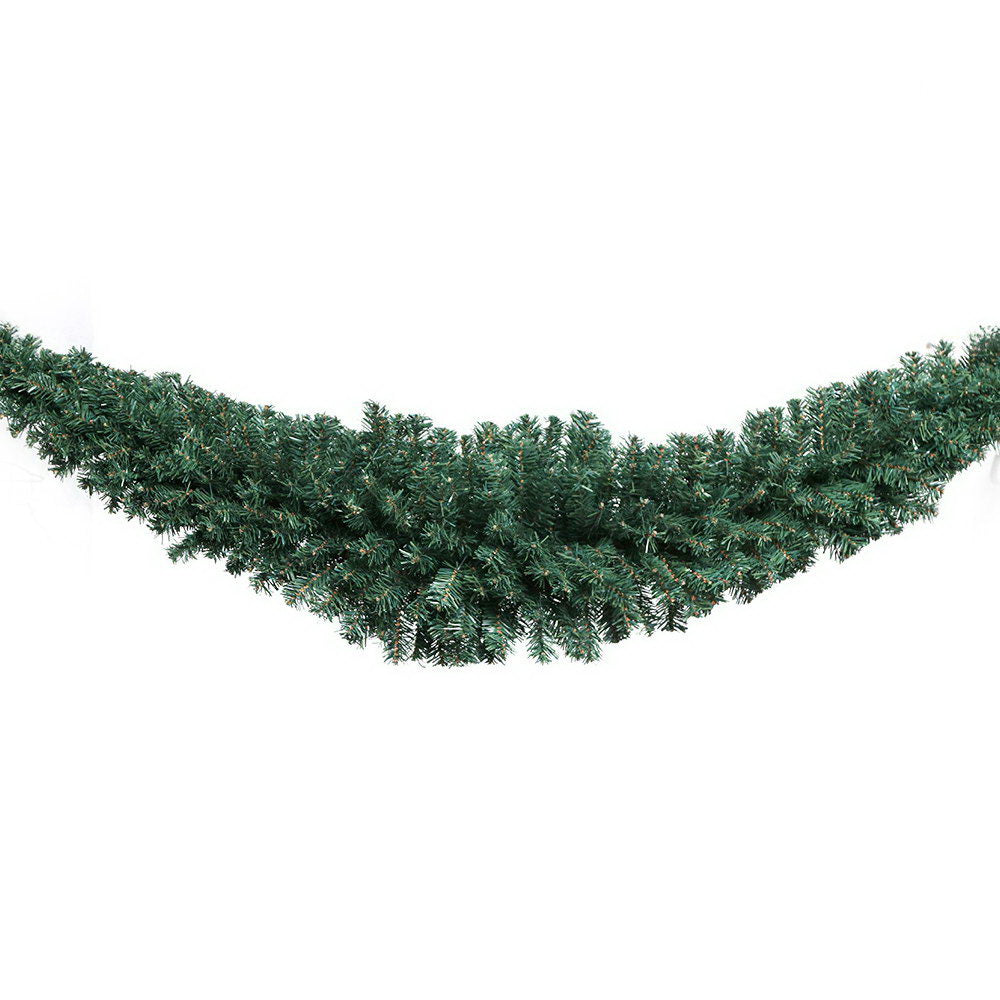 Green Christmas garland with dense pine branches, curved swag style
