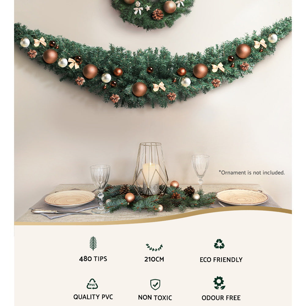 Decorated Christmas garland with pine branches, copper baubles and small bows