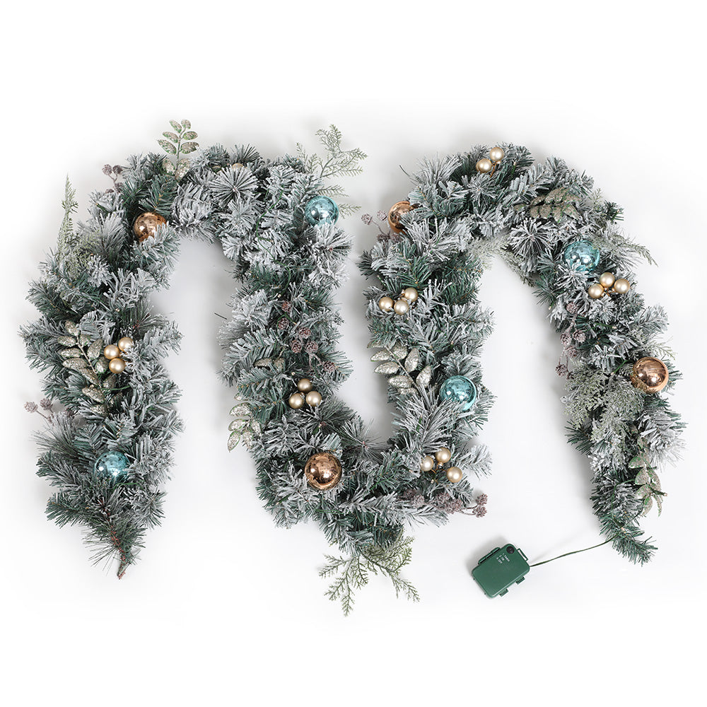 Flocked snowy Christmas garland with LED lights, blue and gold baubles, pine cones