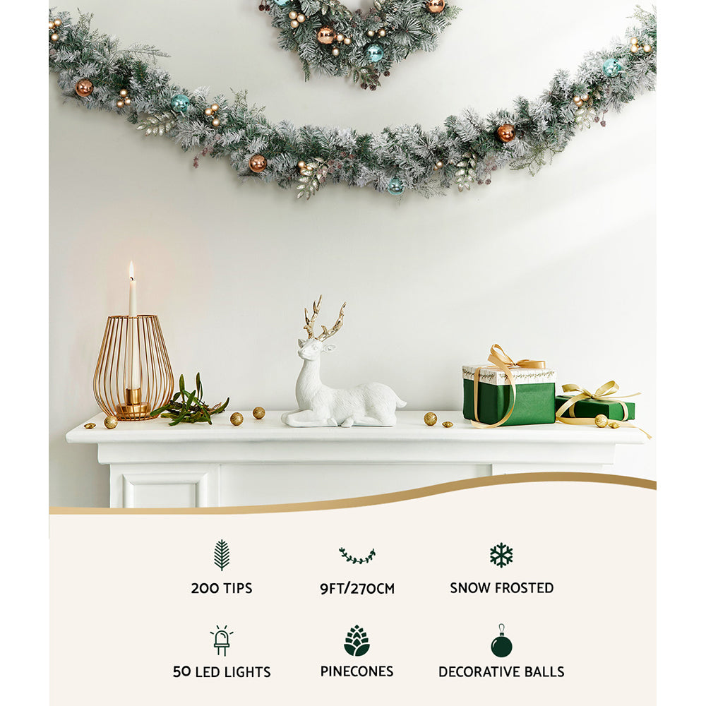 Snowy flocked Christmas garland with warm LED lights and gold, blue decorative balls