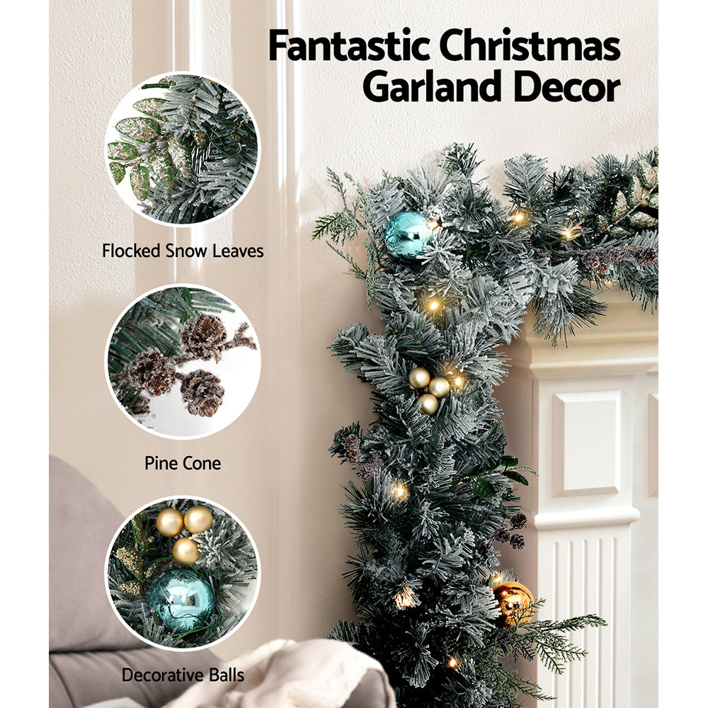 Flocked snowy Christmas garland with cone tips, pine cones, gold and blue LED lights