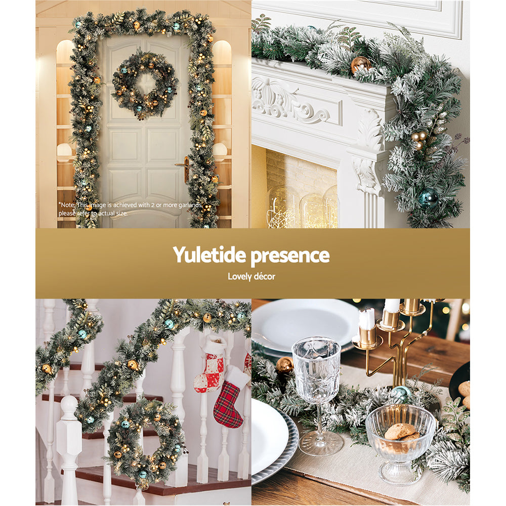 Decorative Christmas garland with LED lights, gold and blue baubles, flocked snow leaves