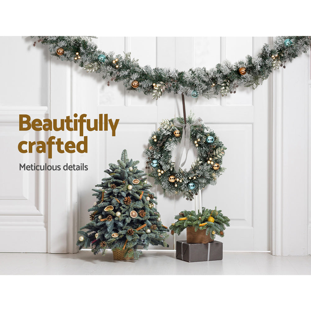 Snowy Christmas garland wreath with warm LED lights and gold, blue, copper ornaments