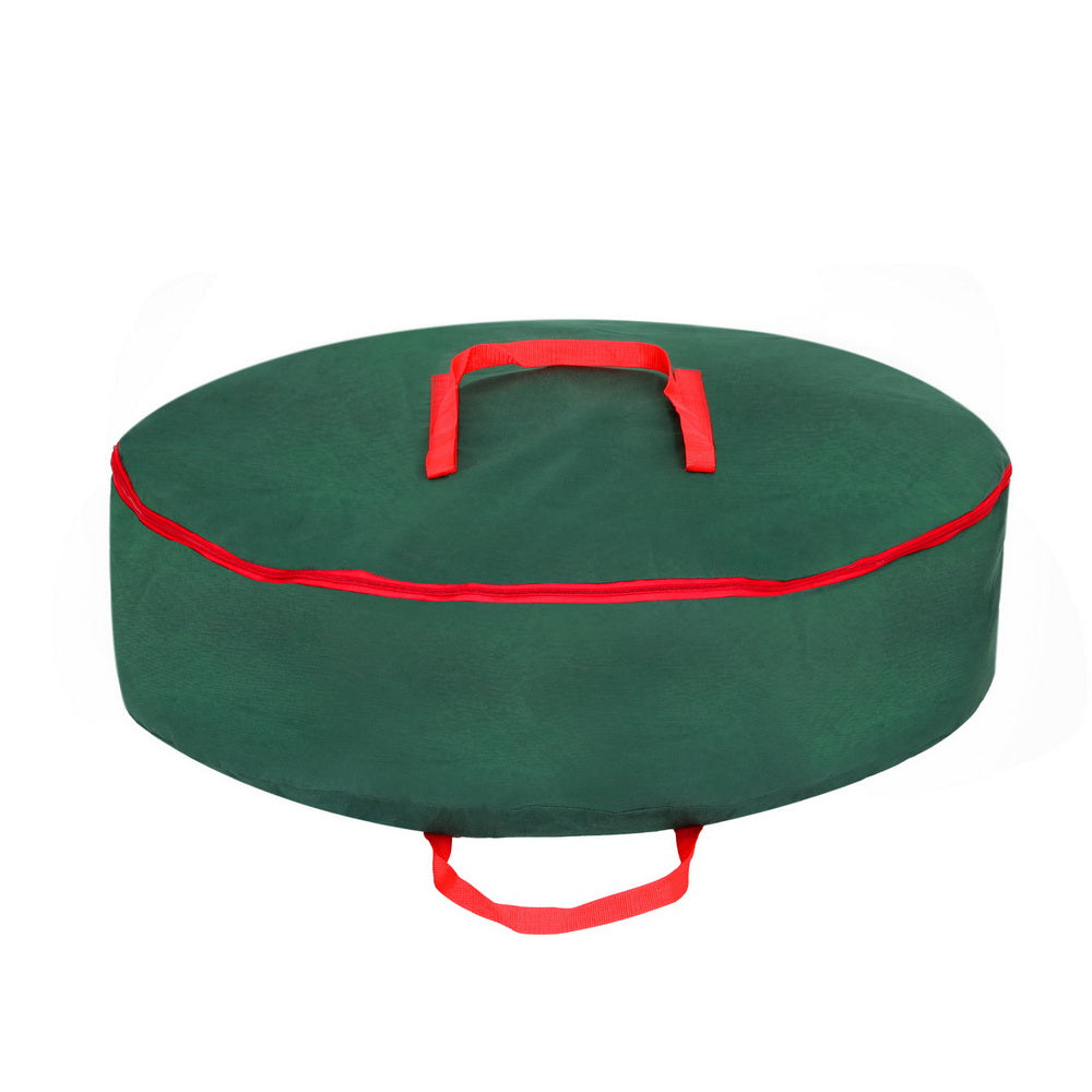 Green round Christmas wreath storage bag with red top handle and carry strap