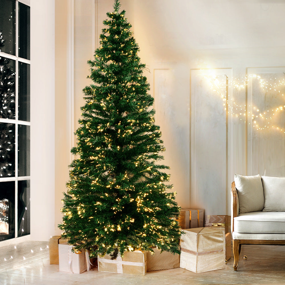 Green prelit Christmas tree with warm white twinkling optic fibre LED lights on stand