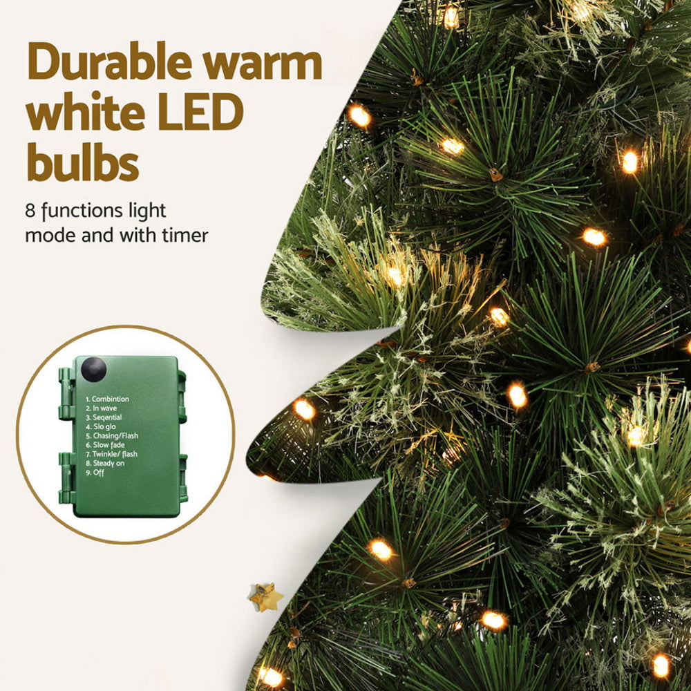 Close-up of warm white LED bulbs on dark green Christmas tree branches