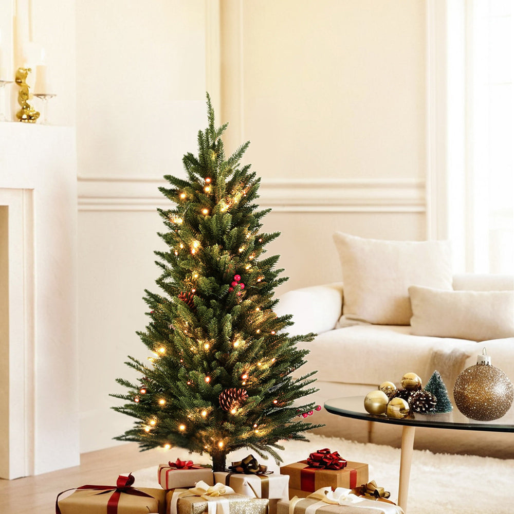 Mini Christmas tree with green branches and warm LED lights, pinecone berry decorations