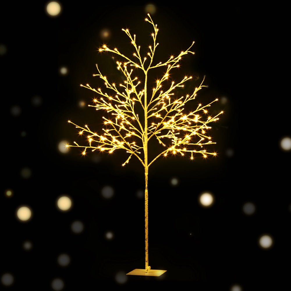 Lighted Christmas tree with warm white LED branches and base stand, close view