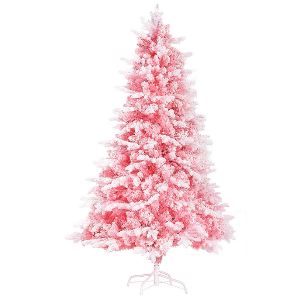 Pink snowy Christmas tree with dense flocked branches and star topper