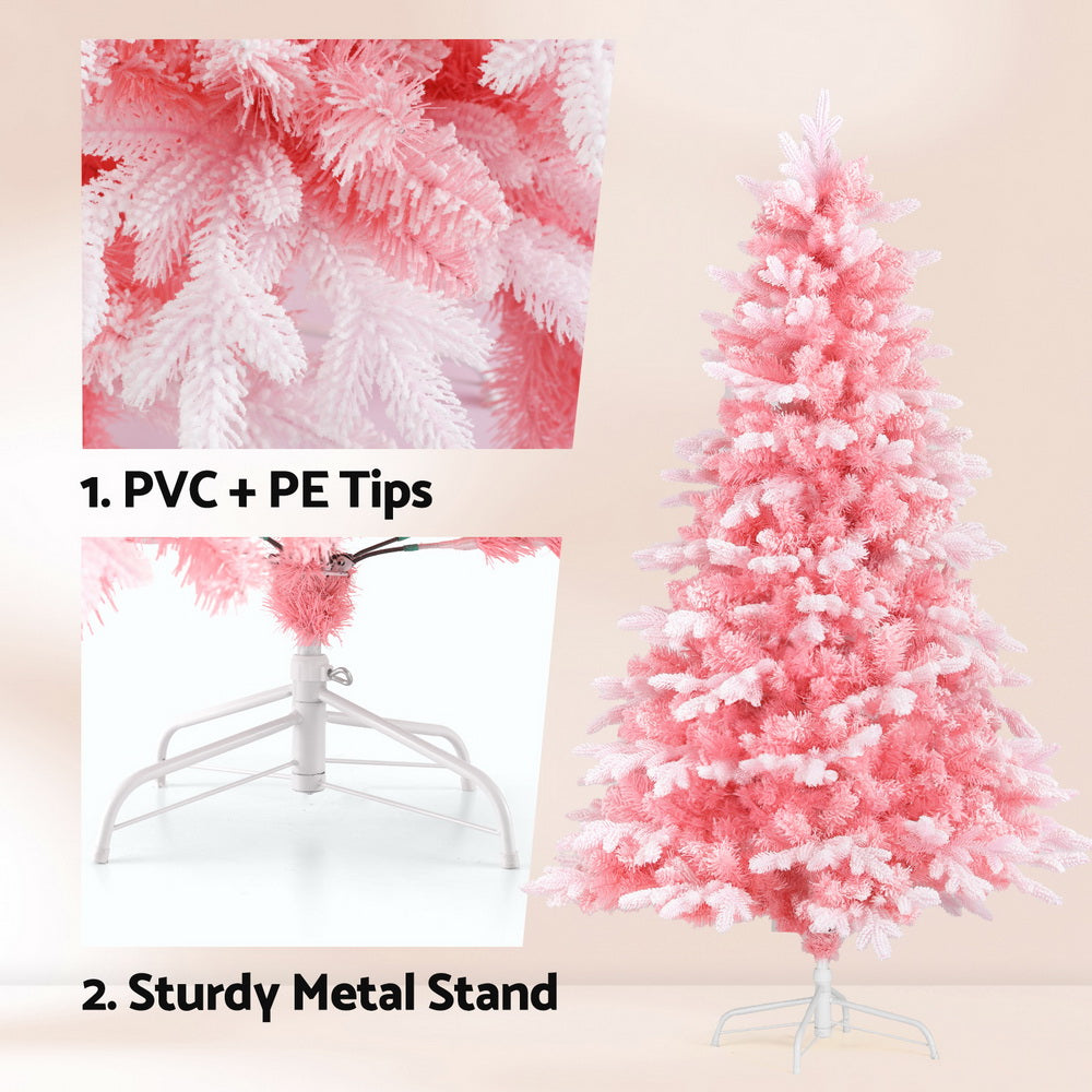 Pink snowy Christmas tree with white-flocked tips on a metal stand