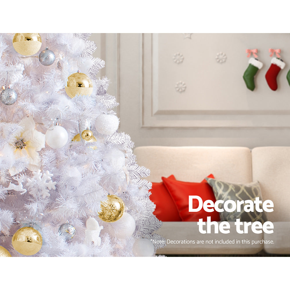 Artificial Christmas tree with white tips and gold, white, and silver bauble ornaments