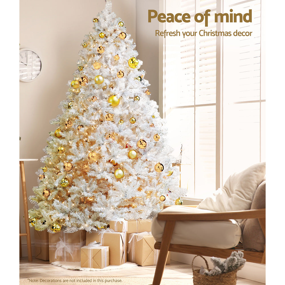 Artificial Christmas tree with white tips, gold bauble ornaments, and a star topper