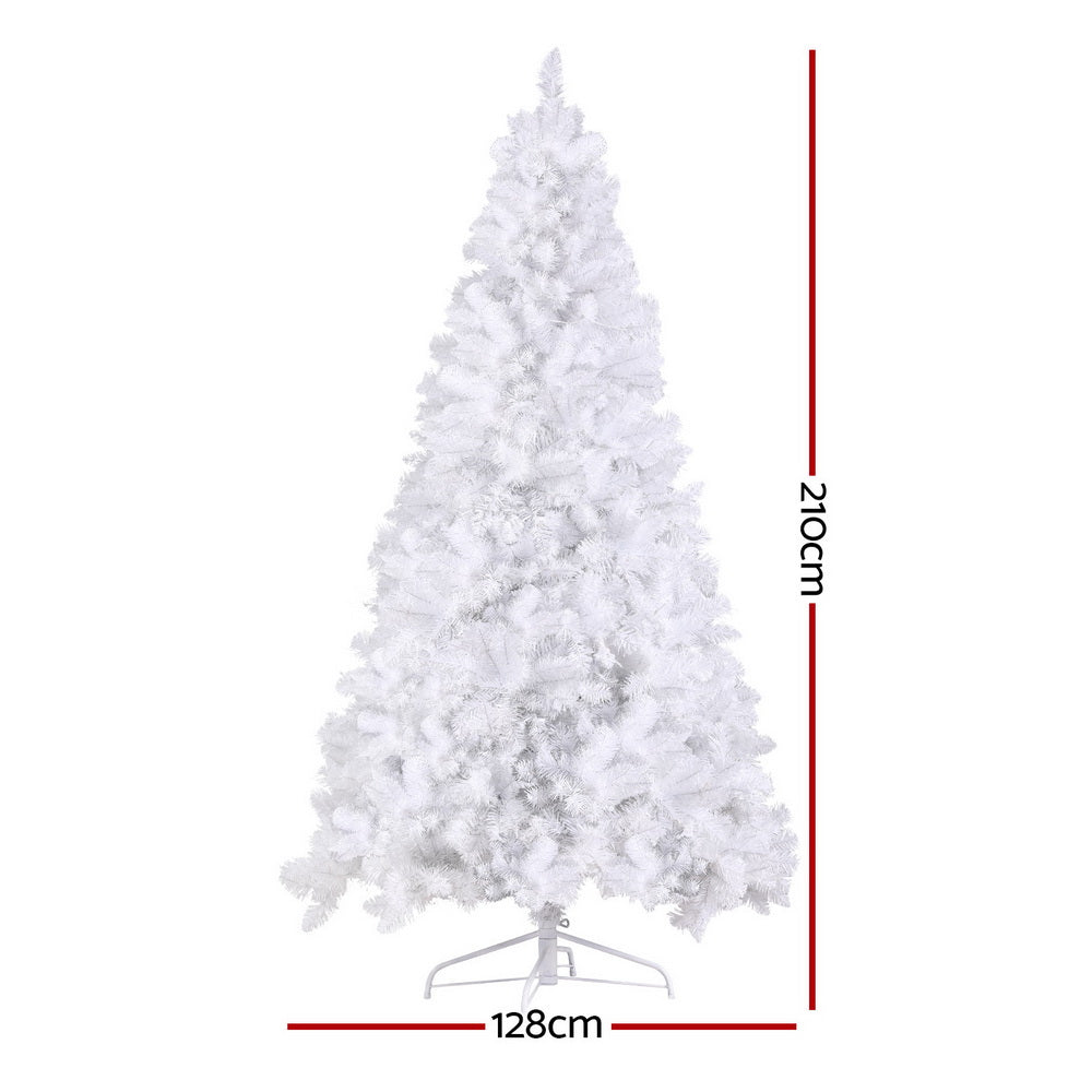 White flocked Christmas tree with warm LED lights, set on silver metal stand