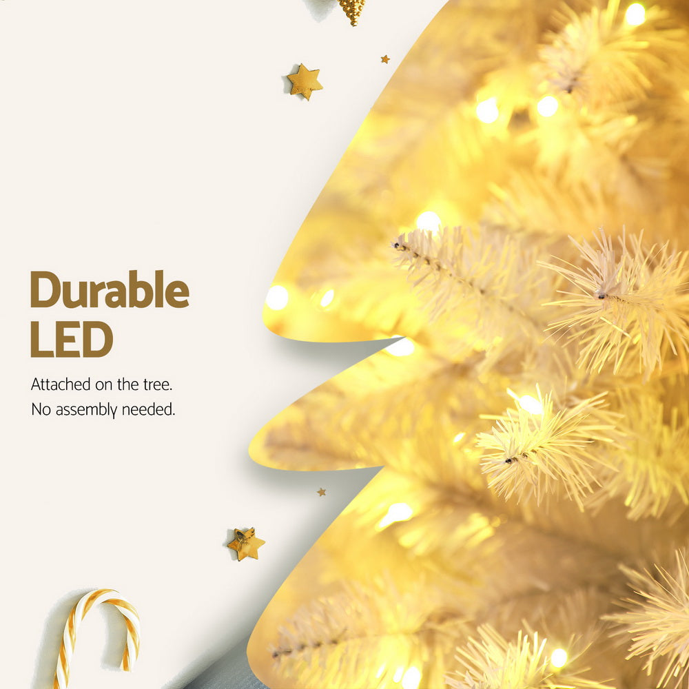 Warm LED light strands on white flocked Christmas tree tips, close-up
