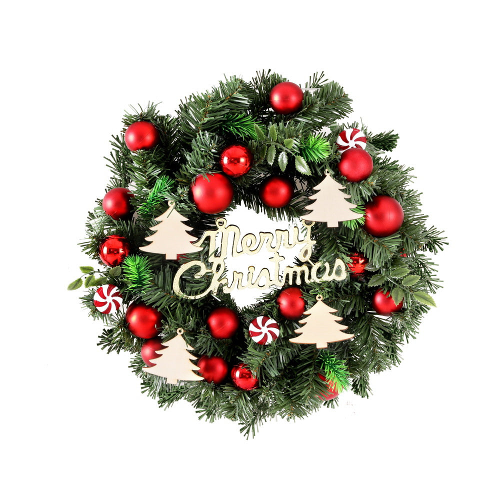 Christmas wreath of green pine with red baubles, candy cane ornaments, and 'Merry Christmas' sign