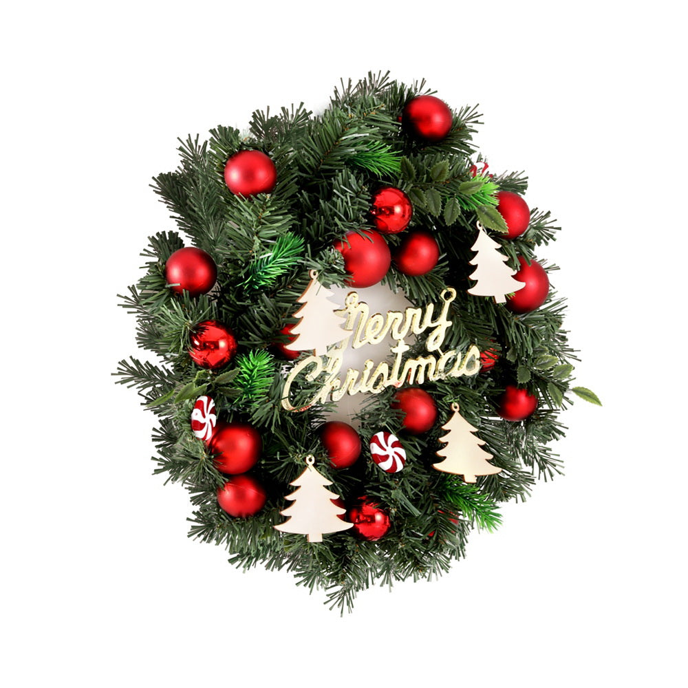 Christmas wreath with green pine, red baubles, candy cane ornaments and 'Merry Christmas' sign