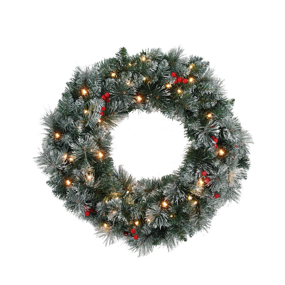Snowy Christmas wreath with warm LED lights and red berries, full round