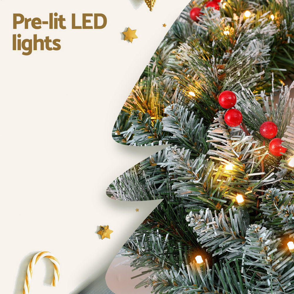 Pre-lit LED Christmas wreath with frosted pine, warm lights, and red berries