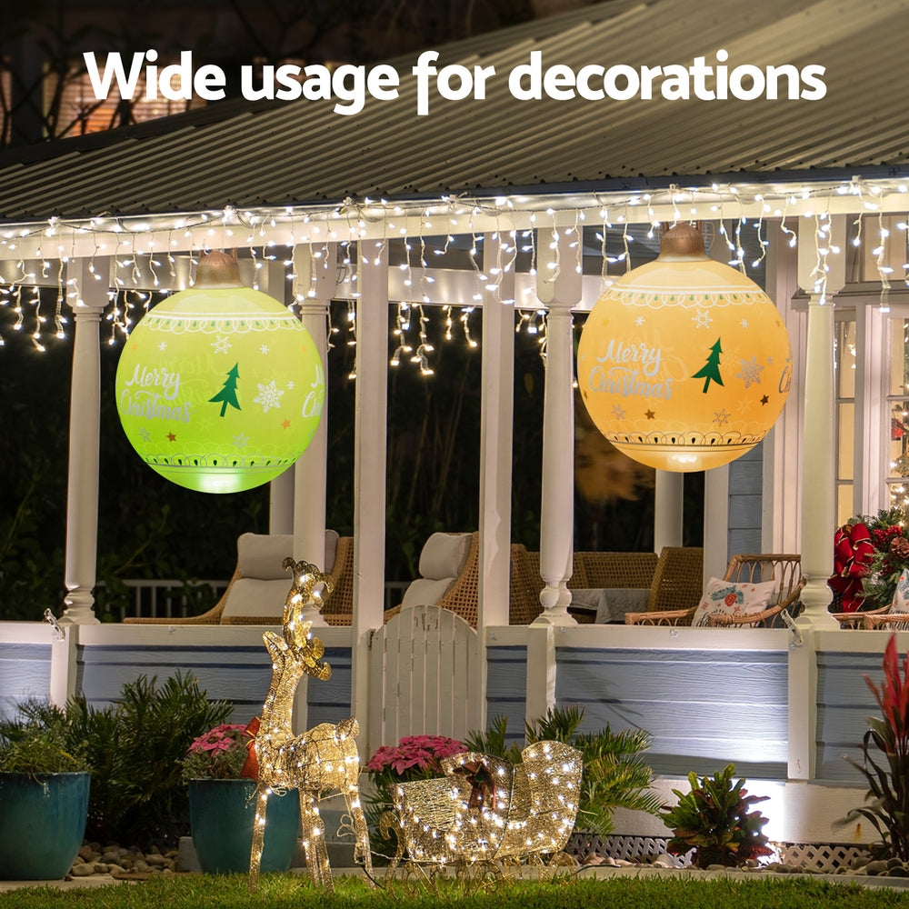 Two yellow Christmas inflatable LED balls with Merry Christmas and tree graphics