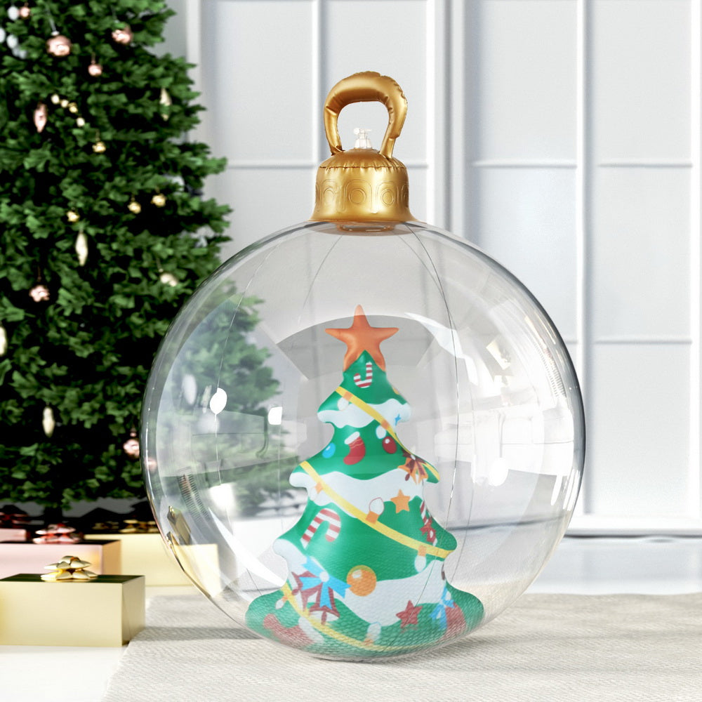 Clear inflatable Christmas bauble with gold top handle and tree design, outdoors