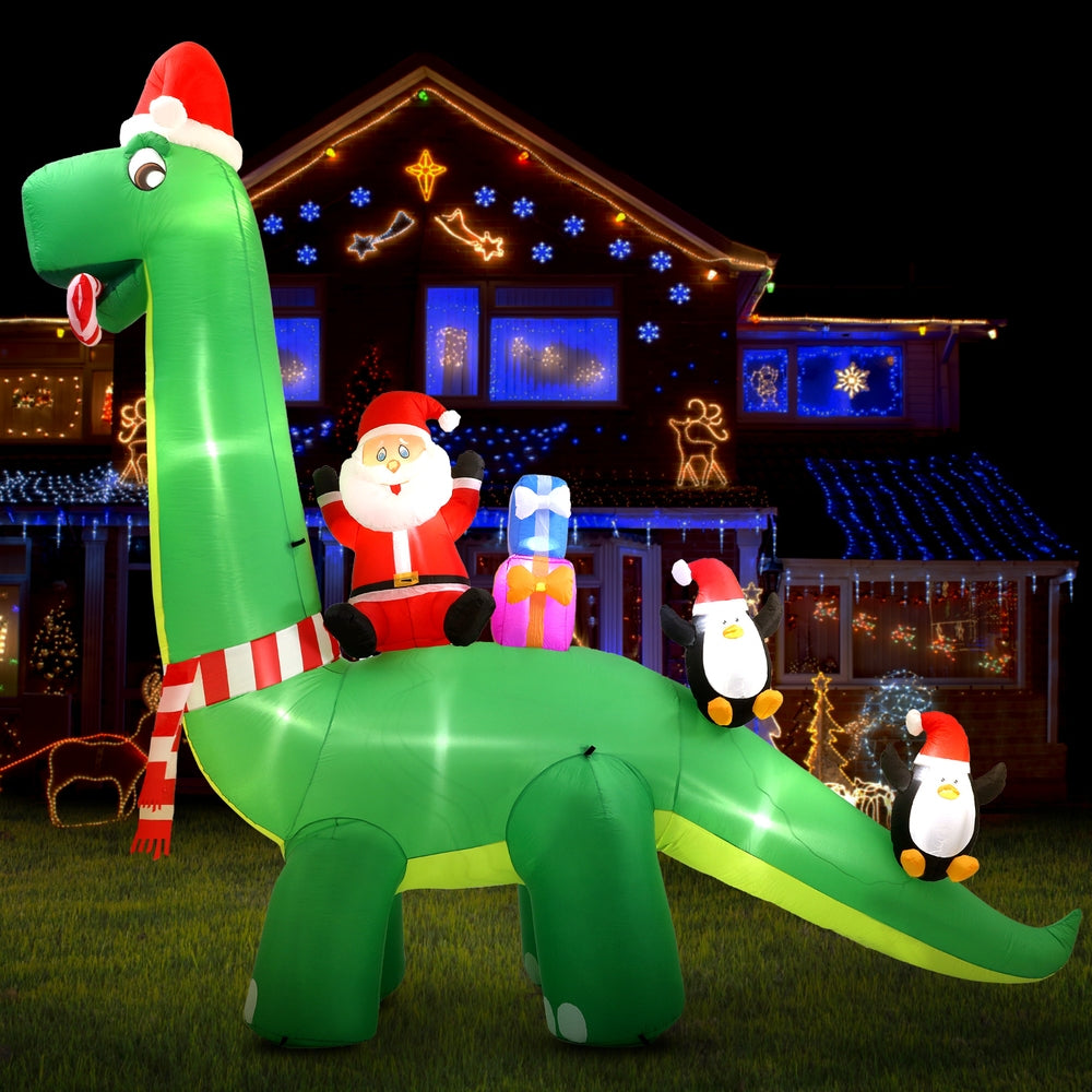 Green illuminated inflatable Santa riding dinosaur with penguin light figures