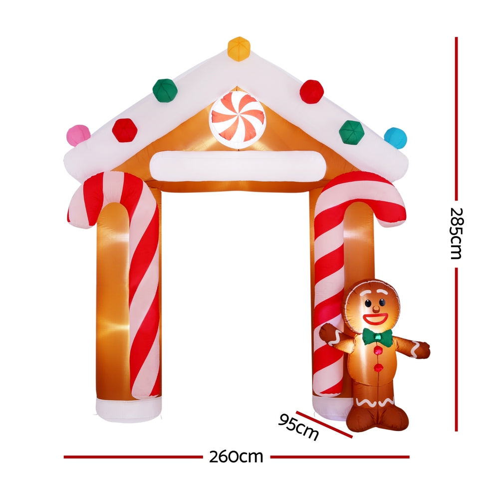 Inflatable gingerbread doorway arch with candy-cane side panels and multicolor roof lights