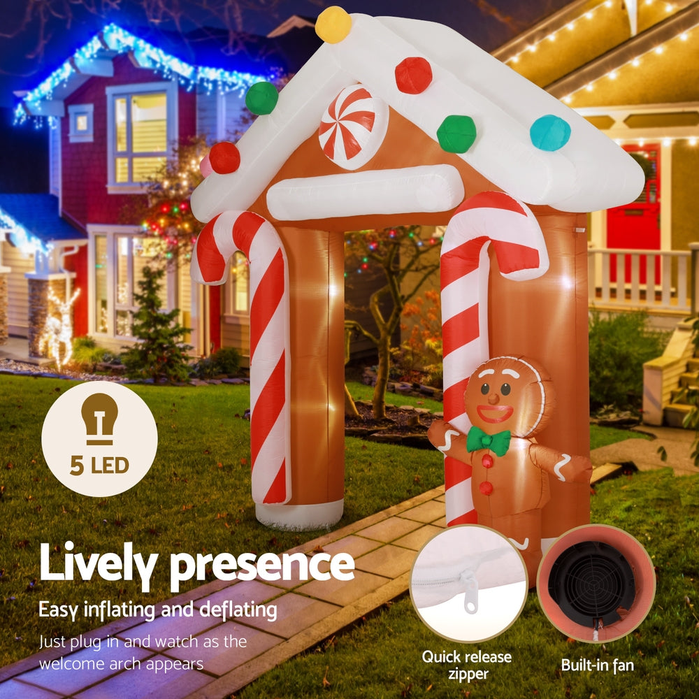 Glowing inflatable Christmas arch with gingerbread character and candy-cane pillars