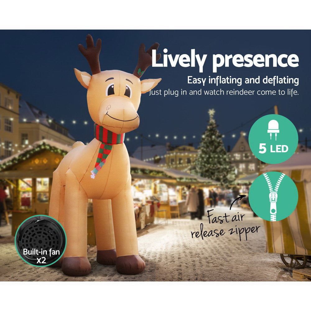 Illuminated inflatable reindeer decoration with striped scarf, standing in outdoor holiday setting