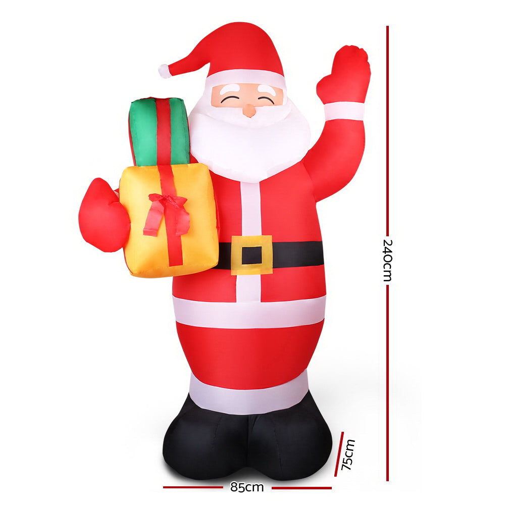 Inflatable Santa Christmas decoration in red-and-white stripes, holding a gift bag, raised arm