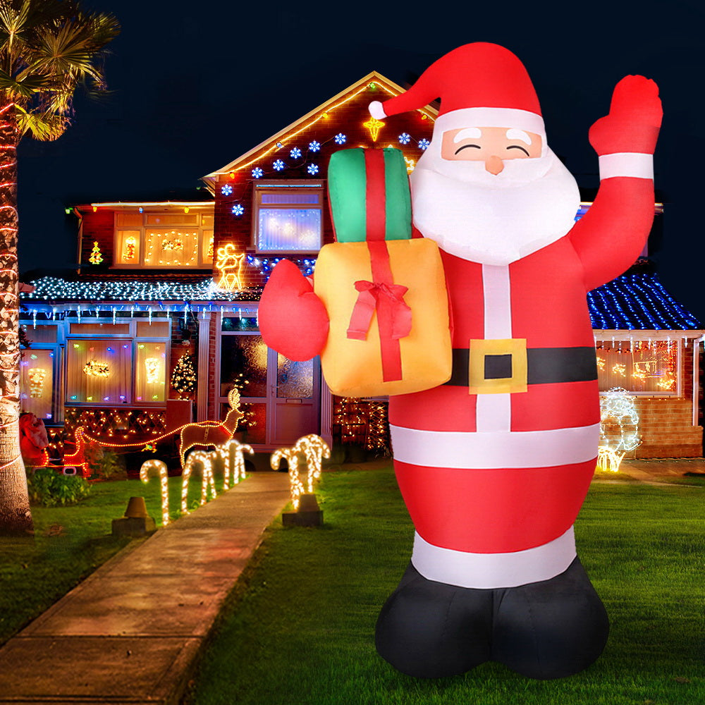 Illuminated inflatable Santa decoration with gift bag, red-and-white striped suit, raised arm