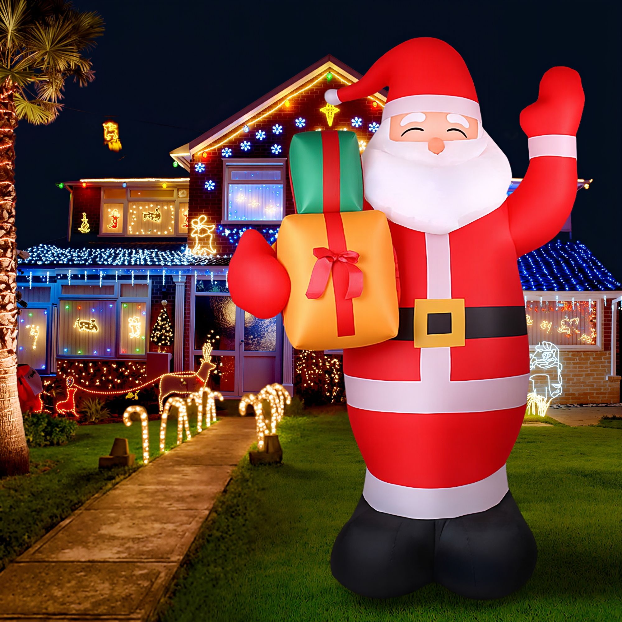 Inflatable Santa decoration with gift bag in front of lit house decorations
