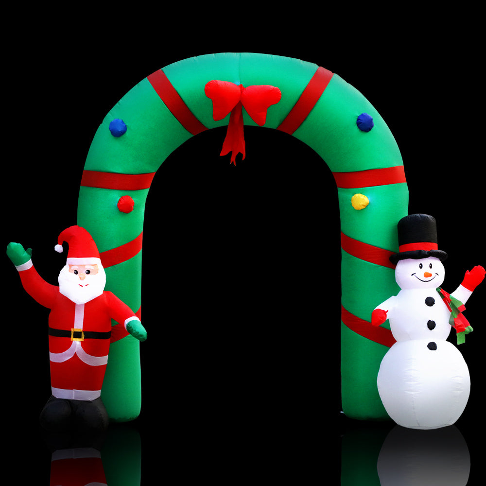 Inflatable Christmas archway with red elf figure and white snowman beside green striped arch