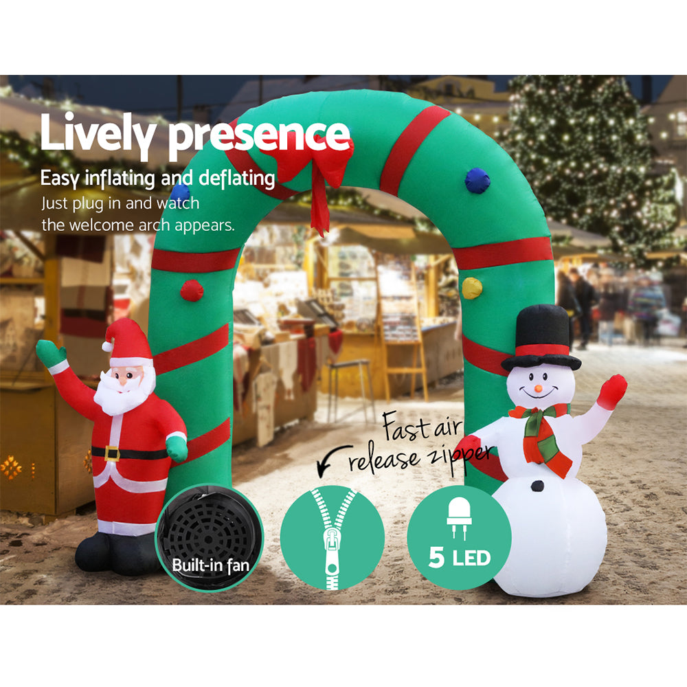 Inflatable Christmas archway with red elf and white snowman, illuminated for the holidays