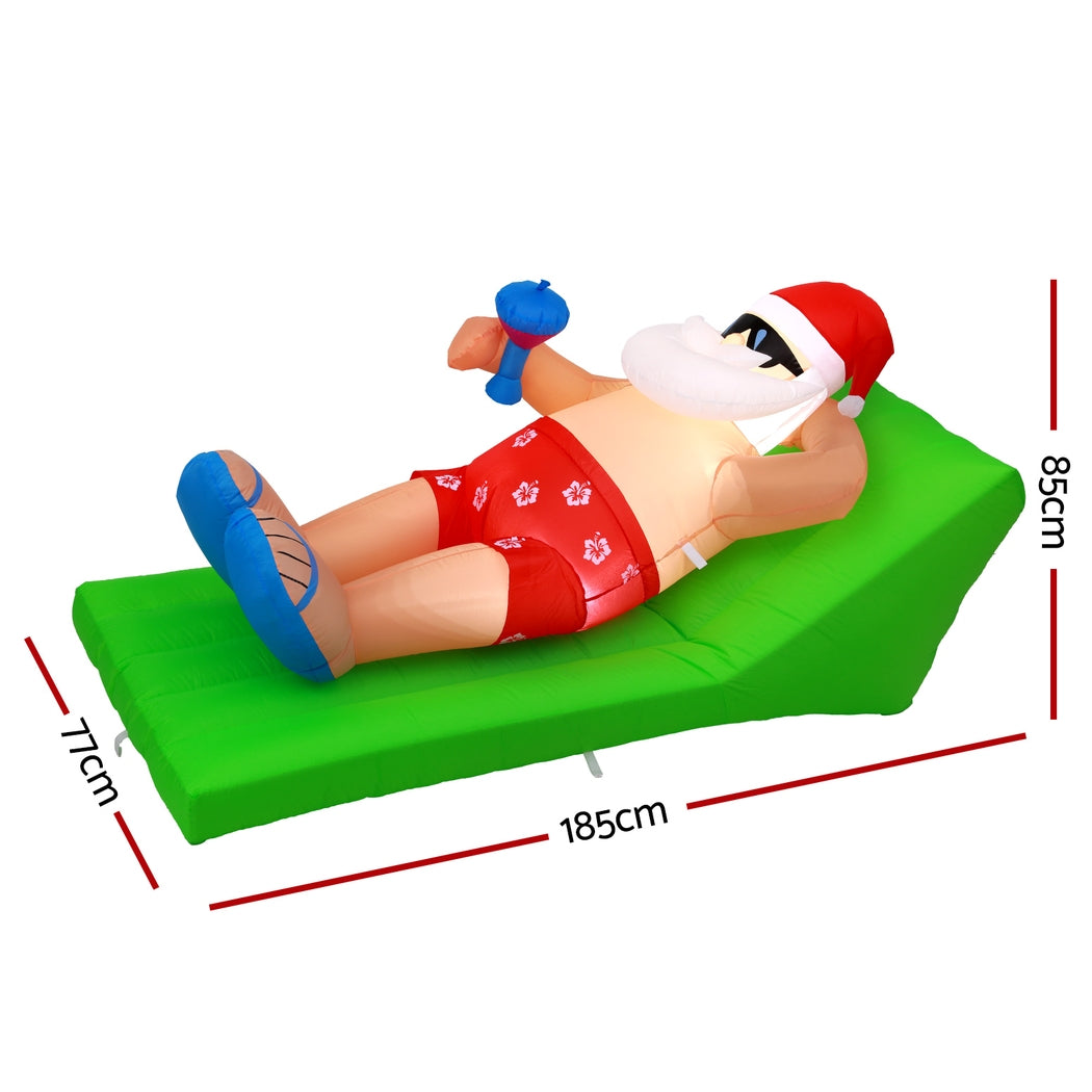 Inflatable Santa bench on green cushion with Santa in red; approx 185×85×71 cm.