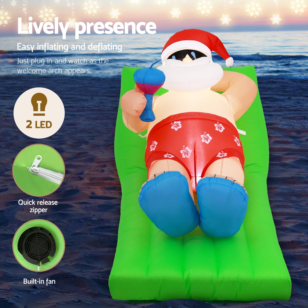 Inflatable Santa bench with Santa in red suit, white beard and hat, blue gloves, on green cushion.