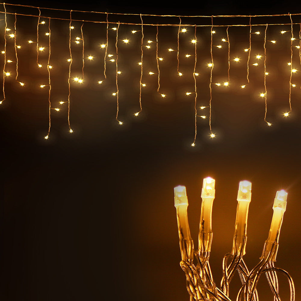 Warm white solar icicle string lights close-up with glowing bulbs and twisted wire