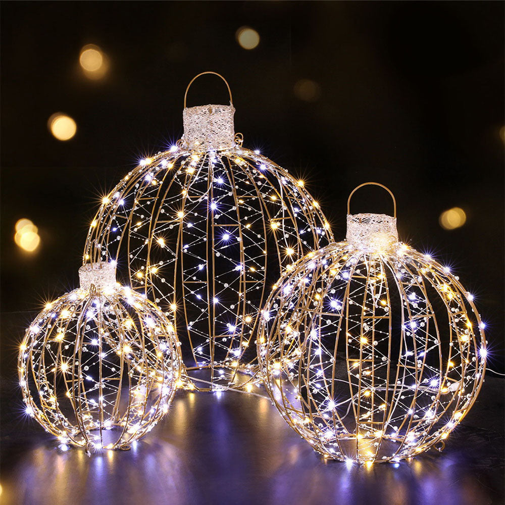 Three gold wire LED light ball ornaments with warm white bulbs, hanging for display