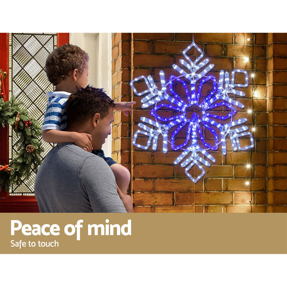 LED snowflake motif light decoration on a wall with blue glowing bulbs