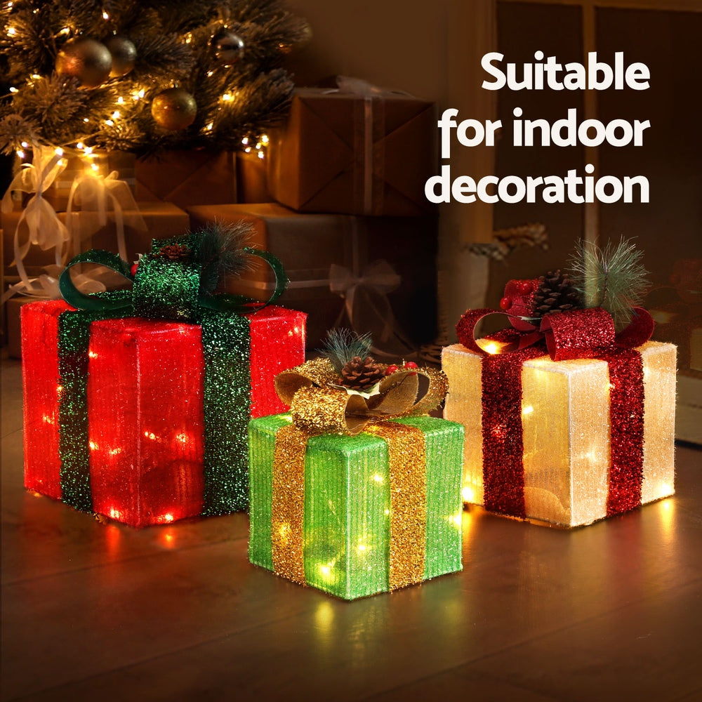 Glowing Christmas gift box fairy lights with ribbon bows in red, green, white, and gold tones.