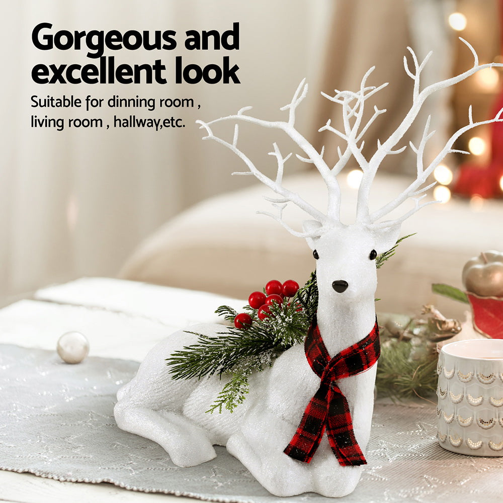 Christmas deer ornament, plush white reindeer with antlers, plaid scarf, green pine sprigs and red berries.