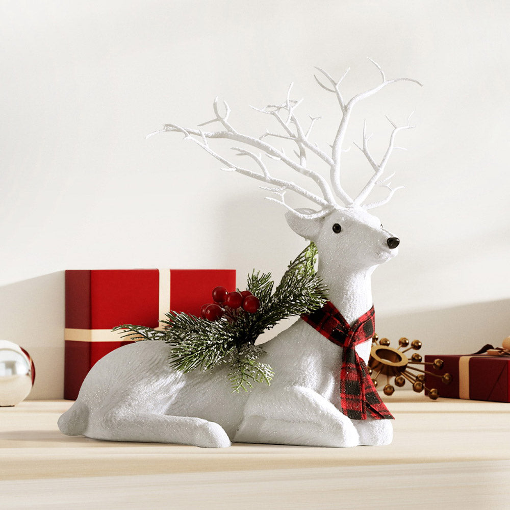 Christmas deer ornament, plush white reindeer with antlers, plaid scarf, pine sprigs and red berries on base.